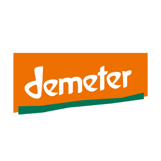 Das Bild zeigt ein Logo mit orangefarbenem Hintergrund. Darauf steht der weiße Schriftzug „demeter“ in Kleinbuchstaben. Unter dem Schriftzug befindet sich eine grüne Linie.